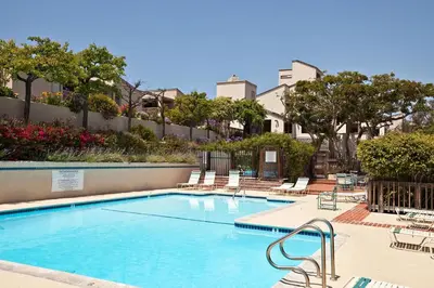 a swimming pool with lounge chairs in a resort at Sun, Sand, & Vitamin Sea - SUR5 in Solana Beach
