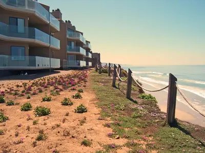 a building on the beach next to the ocean at Relax & Renew - SONG8 in Solana Beach