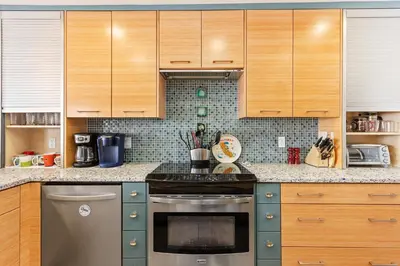 a kitchen with wooden cabinets and a stove top oven at Sea Forever - DMST3536 in Solana Beach