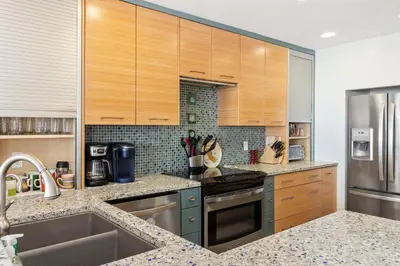a kitchen with wooden cabinets and stainless steel appliances at Sea Forever - DMST3536 in Solana Beach