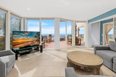 a living room with a large tv and a table at Sea Forever - DMST3536 in Solana Beach