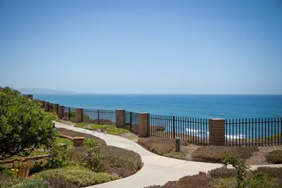a walkway next to the beach with a fence at Sea-renity - DMST79 in Solana Beach