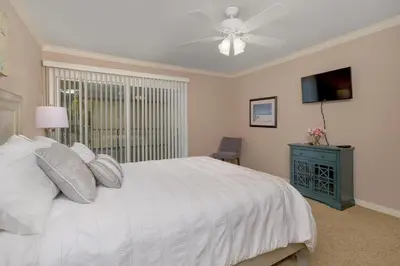 a bedroom with a white bed and a ceiling fan at Sea'Esta by the Shore-DMBC852S in Solana Beach