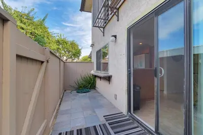 a patio with a sliding glass door next to a building at Sea'Esta by the Shore-DMBC852S in Solana Beach