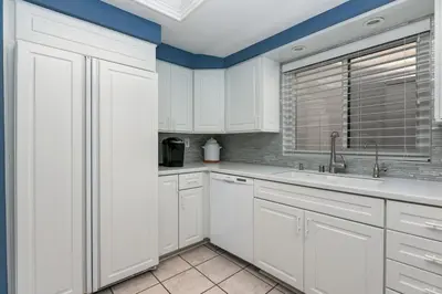 a white kitchen with a sink and a window at A Wave From It All - SUR42 in Solana Beach