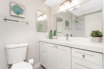a white bathroom with a toilet and a sink at Endless Summer - SUR149 in Solana Beach