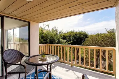 a patio with a table and chairs on a balcony at Endless Summer - SUR149 in Solana Beach