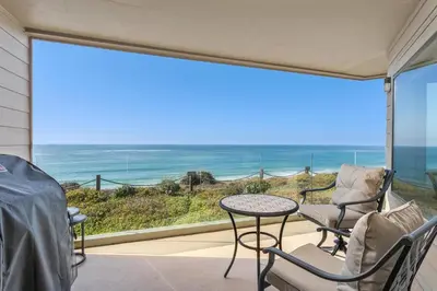 a balcony with chairs and a table and a view of the ocean at Don't Worry Beach Happy SONG13 in Solana Beach