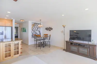 a living room with a television and a table with chairs at A Shore Thing! - DMST21 in Solana Beach