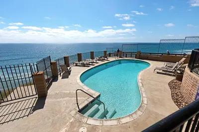 a swimming pool with the ocean in the background at A Shore Thing! - DMST21 in Solana Beach