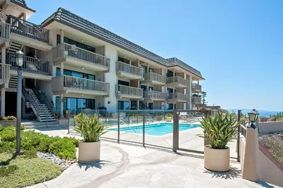 an apartment building with a swimming pool and plants at Beach View Beauty - DMBC775D in Solana Beach