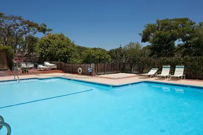 a large swimming pool with two chairs at Escape at Seascape - SUR112 in Solana Beach