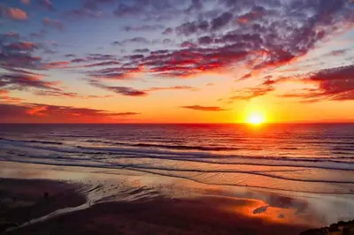 a sunset on a beach with the ocean at Escape at Seascape - SUR112 in Solana Beach