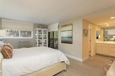 a bedroom with a large bed and a bathroom at Beach You To It! - SUR61 in Solana Beach