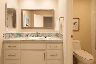 a bathroom with a sink and a toilet and a mirror at Beach You To It! - SUR61 in Solana Beach