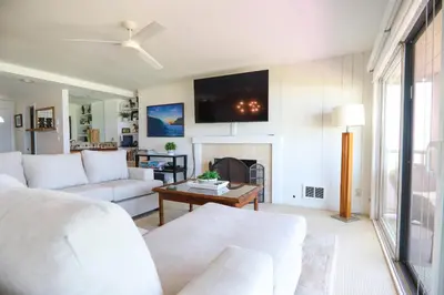 a living room with a white couch and a fireplace at Pacific Perch - SUR115S in Solana Beach