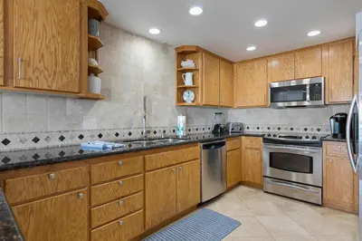 a kitchen with wooden cabinets and stainless steel appliances at Pacific Perch - SUR115S in Solana Beach