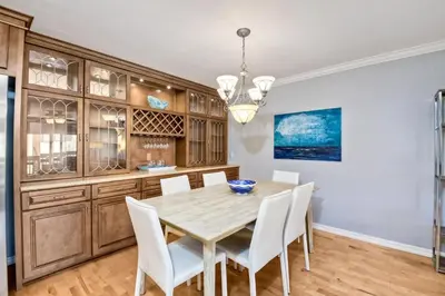 a dining room with a wooden table and white chairs at Ocean Dreams - SBTC145 in Solana Beach