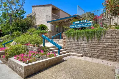 a street sign in front of a building with flowers at Ocean Dreams - SBTC145 in Solana Beach
