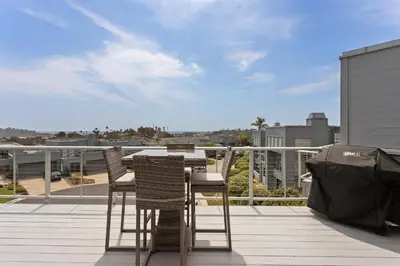 a patio with chairs and a table on a balcony at Vista Pacific - DM1050 in Del Mar