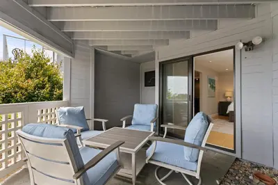 a patio with blue chairs and a wooden table at Vista Pacific - DM1050 in Del Mar