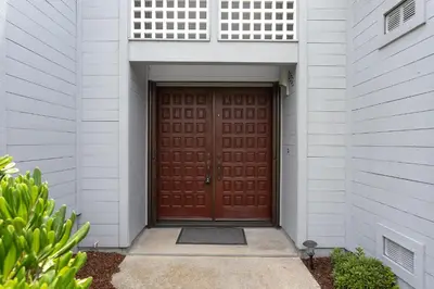 a brown wooden door in a white building at Vista Pacific - DM1050 in Del Mar