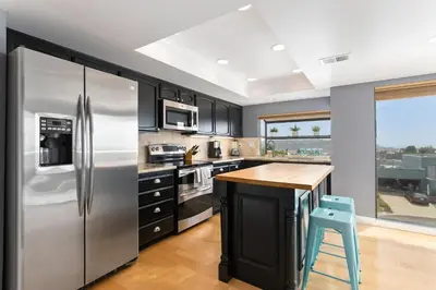 a kitchen with a stainless steel refrigerator and a wooden island at Vista Pacific - DM1050 in Del Mar
