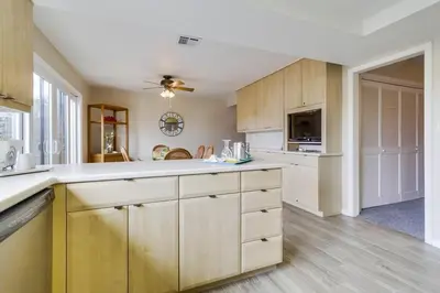 a large kitchen with wooden cabinets and a ceiling fan at Bare Feet &Salty Hair-DMBC141S in Solana Beach