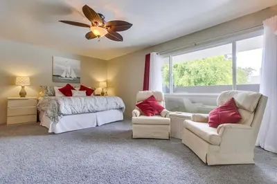 a bedroom with a bed and two chairs and a window at Bare Feet &Salty Hair-DMBC141S in Solana Beach