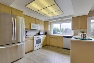 a kitchen with wooden cabinets and stainless steel appliances at Bare Feet &Salty Hair-DMBC141S in Solana Beach