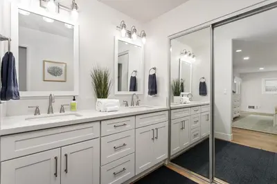 a white bathroom with two sinks and a shower at Cast-a-Waves - SUR29 in Solana Beach