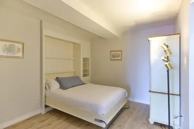 a small bedroom with a bed and shelves at Barefoot Oasis - SUR127 in Solana Beach