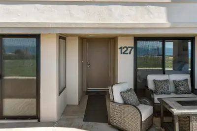a porch with two chairs and a table with at Barefoot Oasis - SUR127 in Solana Beach