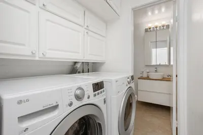 a white laundry room with a washer and dryer at Shore O'Clock - SBTC149 in Solana Beach