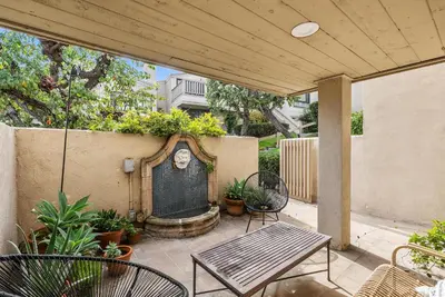 a patio with a table and chairs and a fountain at Hacienda Palms - SUR168 in Solana Beach