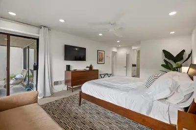a bedroom with a bed and a dresser and a tv at Hacienda Palms - SUR168 in Solana Beach