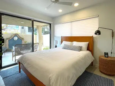 a bedroom with a bed and a large window at Hacienda Palms - SUR168 in Solana Beach