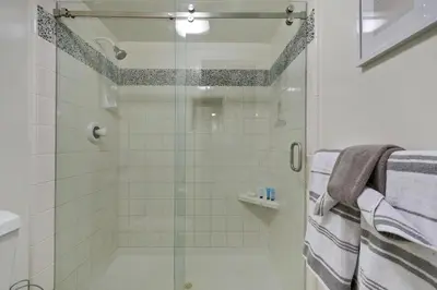 a bathroom with a shower with a glass door at Casa Del Sol - SUR46 in Solana Beach
