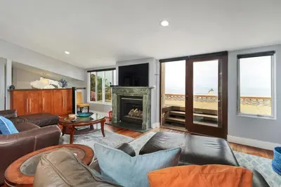 a living room with a couch and a fireplace at Casa Del Sol - SUR46 in Solana Beach