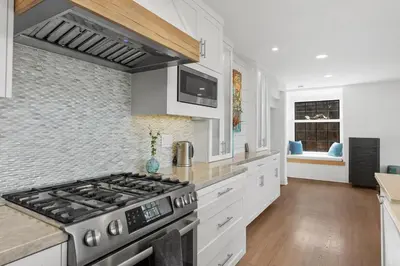 a kitchen with white cabinets and a stove at Torrey View Hideaway in San Diego