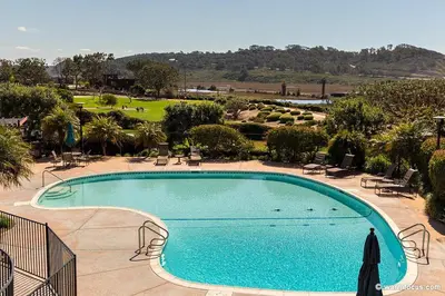 a large swimming pool with chairs and a golf course at Torrey View Hideaway in San Diego