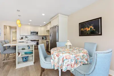 a kitchen and dining room with a table and chairs at Beachfront Bliss - DMBC815 in Solana Beach