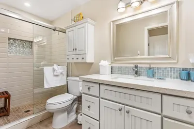a bathroom with a toilet and a sink and a mirror at Beachfront Bliss - DMBC815 in Solana Beach