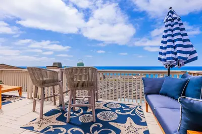 a patio with a table and chairs and an umbrella at Solana Escape - SUR44 in Solana Beach
