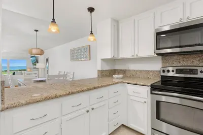 a kitchen with white cabinets and a stove top oven at Sunset Retreat - SUR105 in Solana Beach