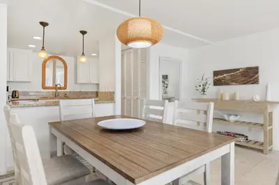 a kitchen and dining room with a wooden table and chairs at Sunset Retreat - SUR105 in Solana Beach