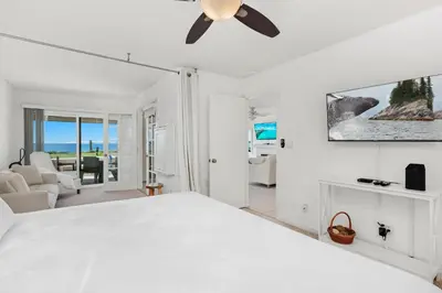 a white bedroom with a bed and a ceiling fan at Sunset Retreat - SUR105 in Solana Beach