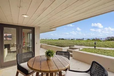 a wooden table and chairs on a patio with a view at Tide and True - SUR129S in Solana Beach