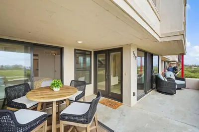 a patio with a wooden table and chairs at Tide and True - SUR129S in Solana Beach
