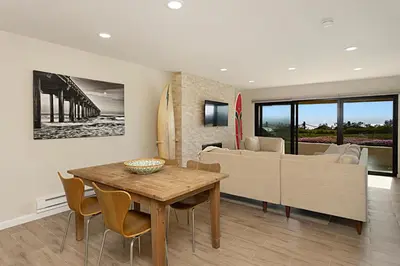 a living room with a table and a couch at Tide and True - SUR129S in Solana Beach